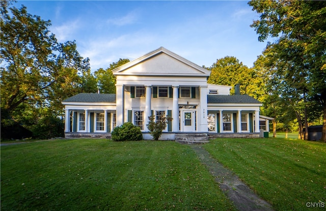 greek revival house featuring a porch and a front yard