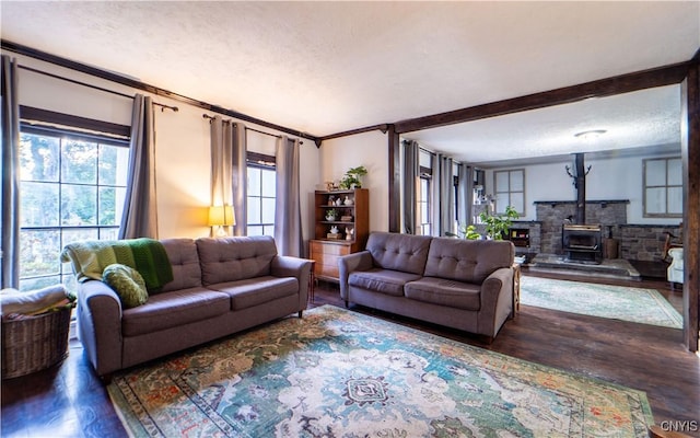 living room featuring a textured ceiling, crown molding, a wood stove, and wood finished floors