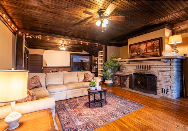 living room featuring a stone fireplace, wooden ceiling, a ceiling fan, and wood finished floors