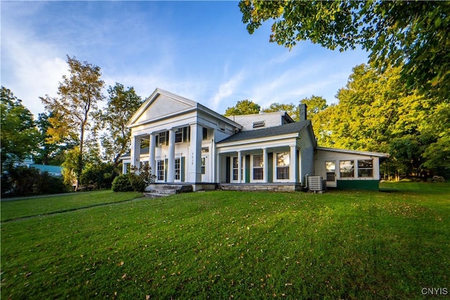 neoclassical / greek revival house featuring central air condition unit and a front yard