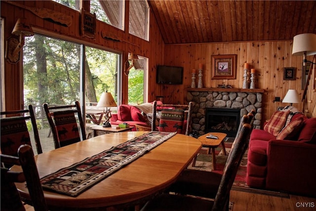 114 Big Moose Lk, Webb, NY 13331 - dining space with wood ceiling, wooden walls, a stone fireplace, wood finished floors, and high vaulted ceiling