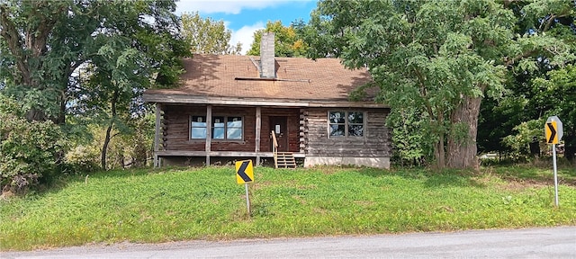 log cabin featuring a porch and a front yard