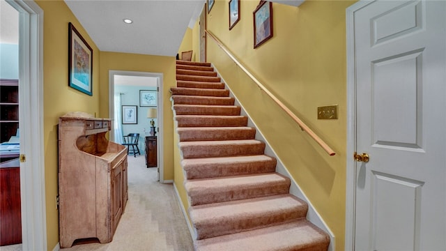 staircase featuring carpet