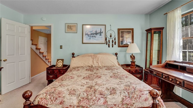 bedroom featuring light carpet and multiple windows