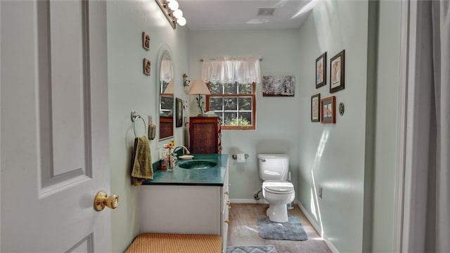 bathroom featuring hardwood / wood-style floors, vanity, and toilet