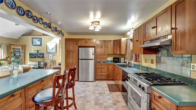 kitchen with decorative backsplash, appliances with stainless steel finishes, and sink