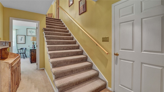 stairs featuring carpet flooring