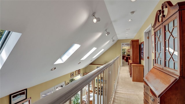 corridor featuring light colored carpet and lofted ceiling with skylight