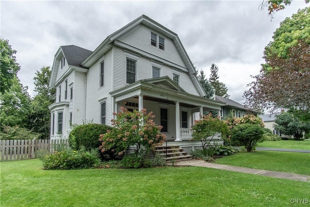 view of front of home featuring a front yard, fence, and covered porch