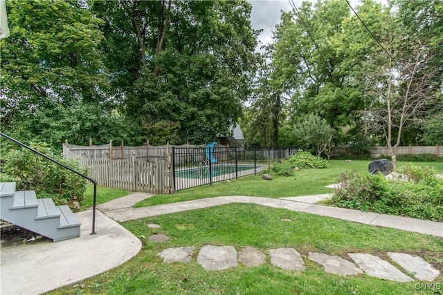 view of property's community with a swimming pool, a yard, and fence