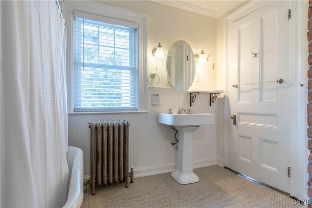 bathroom featuring baseboards, a shower with curtain, radiator heating unit, and crown molding