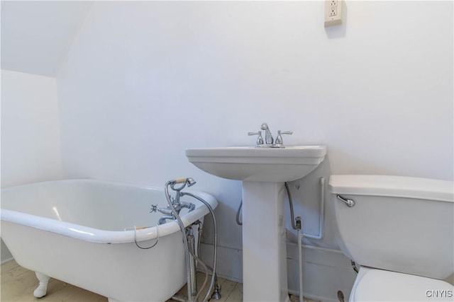 full bath featuring toilet and a freestanding bath