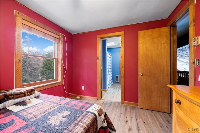 bedroom with multiple windows and light hardwood / wood-style floors