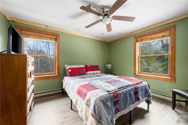 bedroom featuring a baseboard radiator, ceiling fan, light hardwood / wood-style flooring, and multiple windows