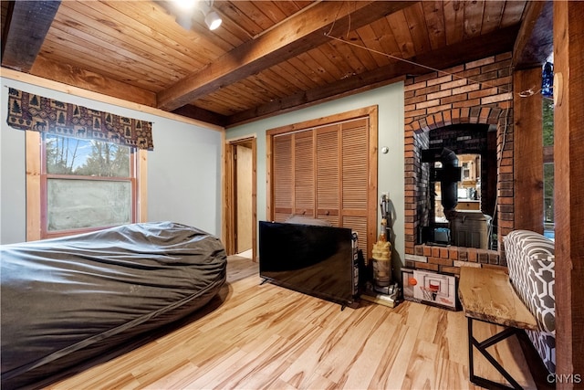 bedroom featuring wooden ceiling, hardwood / wood-style flooring, beam ceiling, and a closet