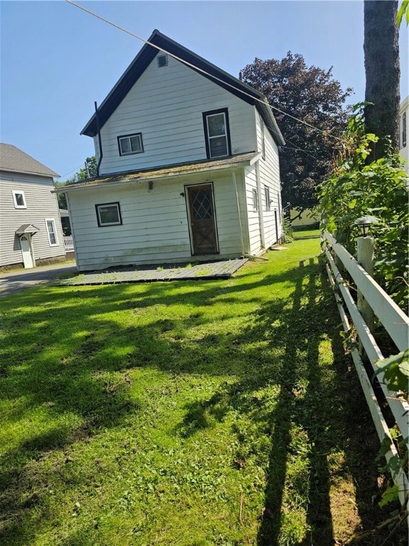 rear view of property featuring a lawn