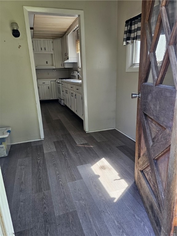 interior space with dark wood-type flooring, white cabinetry, and white electric range oven