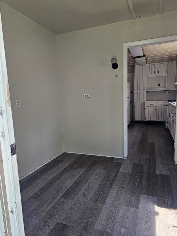 unfurnished room with dark wood-type flooring