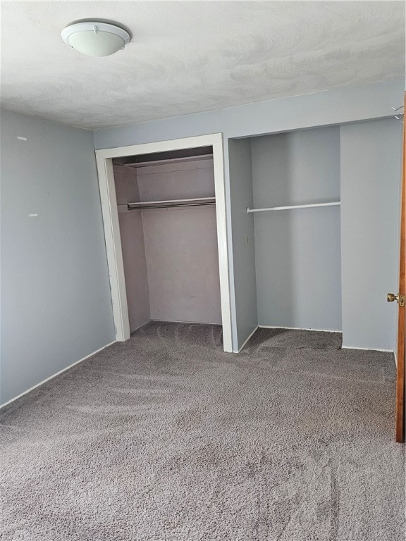 unfurnished bedroom featuring a textured ceiling, a closet, and carpet floors