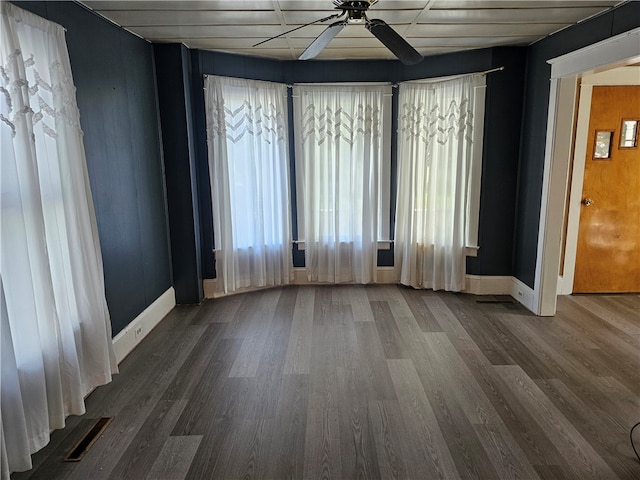 empty room with dark hardwood / wood-style flooring and ceiling fan