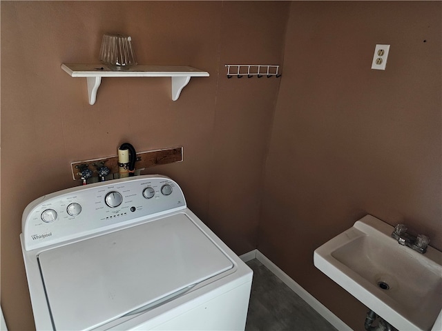 clothes washing area featuring washer / clothes dryer and sink