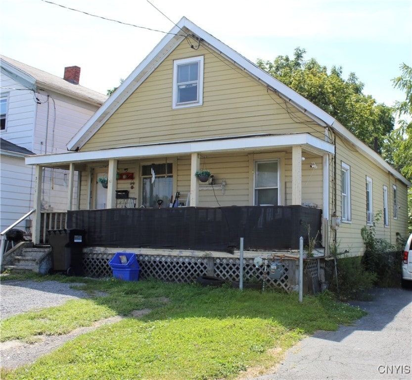 view of front facade featuring a front yard and covered porch