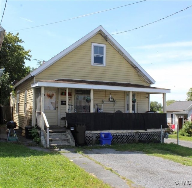 bungalow-style home featuring a front lawn and covered porch