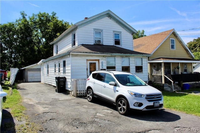 view of front of home with a detached garage, an outbuilding, and a shingled roof