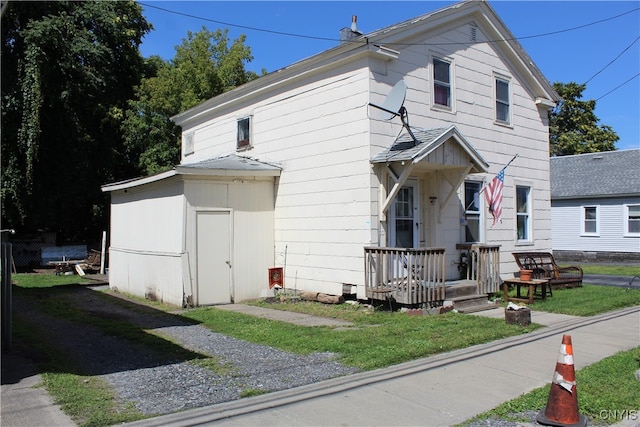 view of front of property with a front lawn and a storage shed