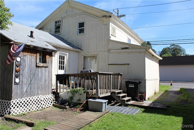 rear view of property with a yard and a wooden deck