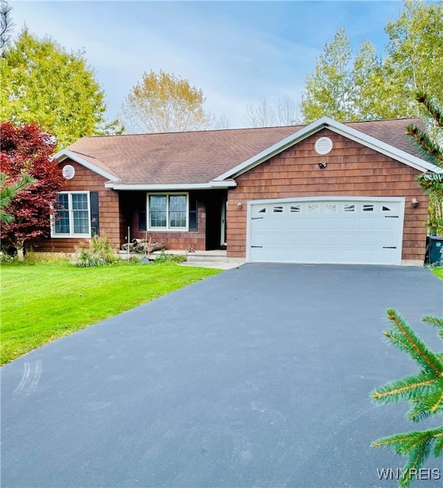 single story home featuring a garage and a front lawn