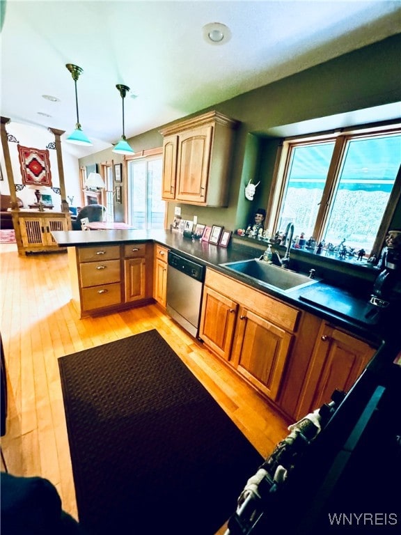 kitchen featuring pendant lighting, light hardwood / wood-style floors, kitchen peninsula, and stainless steel dishwasher