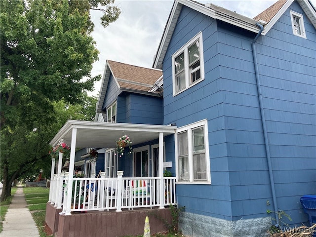 view of side of home with covered porch