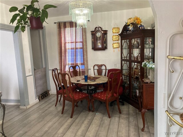 dining area with a notable chandelier and light hardwood / wood-style floors