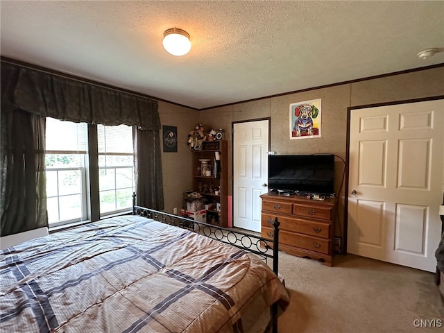 bedroom featuring ornamental molding, a textured ceiling, and carpet