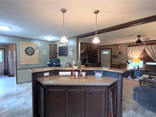 kitchen with pendant lighting, light stone counters, ceiling fan, and dark brown cabinetry