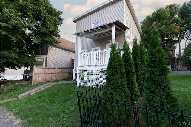 view of front facade with a front lawn and a deck