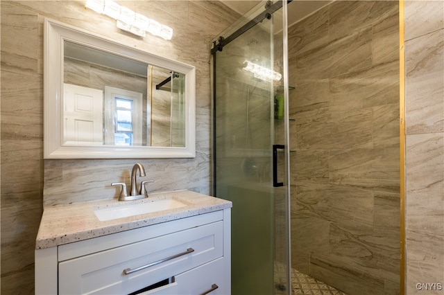 bathroom featuring decorative backsplash, vanity, and a shower with shower door