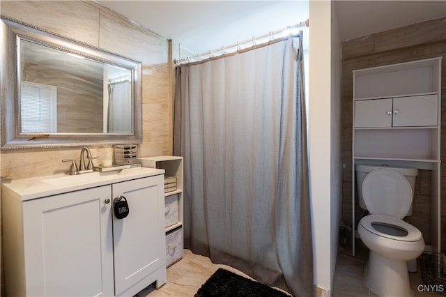 bathroom featuring walk in shower, tile walls, vanity, and toilet