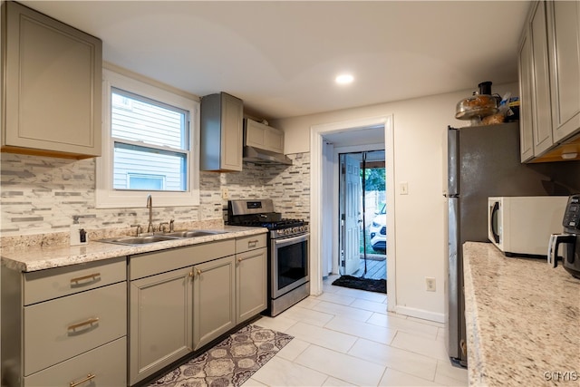 kitchen with backsplash, gas range, sink, and gray cabinets