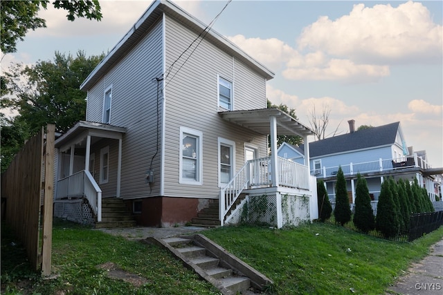 rear view of house featuring a lawn