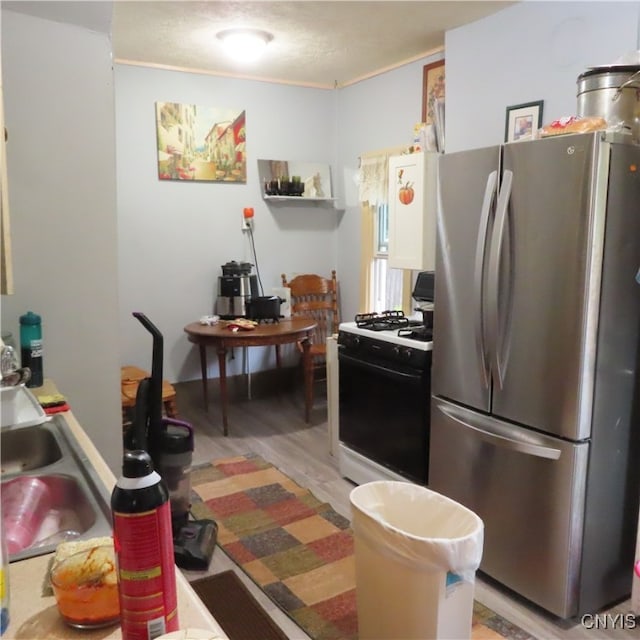 kitchen with light hardwood / wood-style flooring, sink, and white appliances