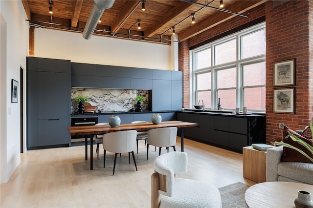 interior space featuring light wood-type flooring, a towering ceiling, beamed ceiling, and wooden ceiling