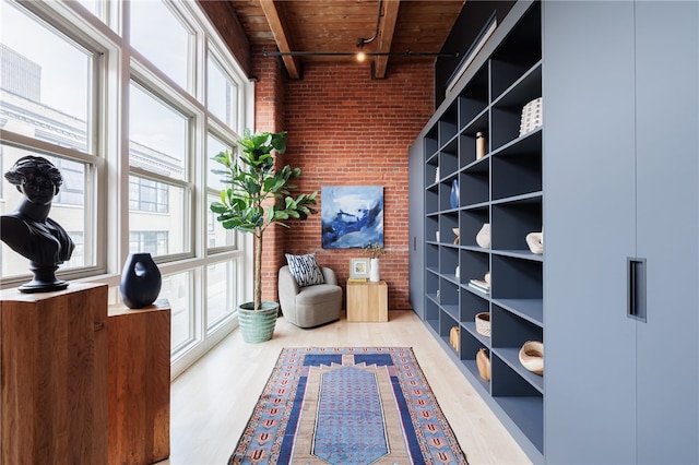 living area with wood ceiling, light hardwood / wood-style floors, beamed ceiling, track lighting, and a high ceiling