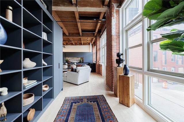 interior space featuring brick wall, beamed ceiling, wood-type flooring, wood ceiling, and track lighting