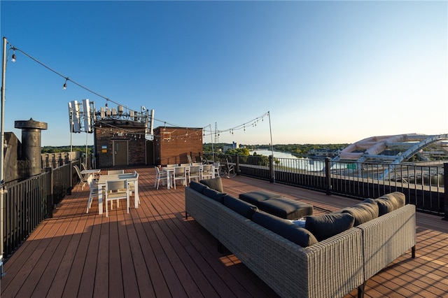 wooden deck with an outdoor living space and a water view