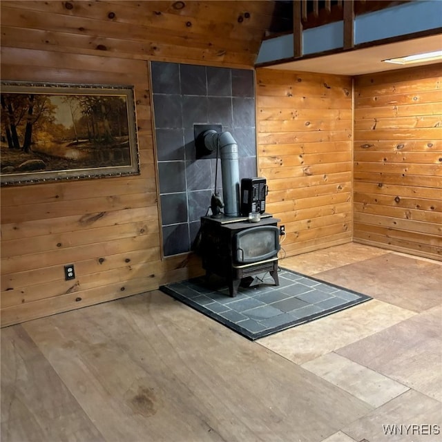 interior details featuring a wood stove and wood walls