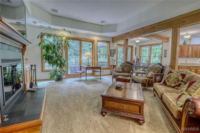 living room featuring carpet, a fireplace, and a wealth of natural light