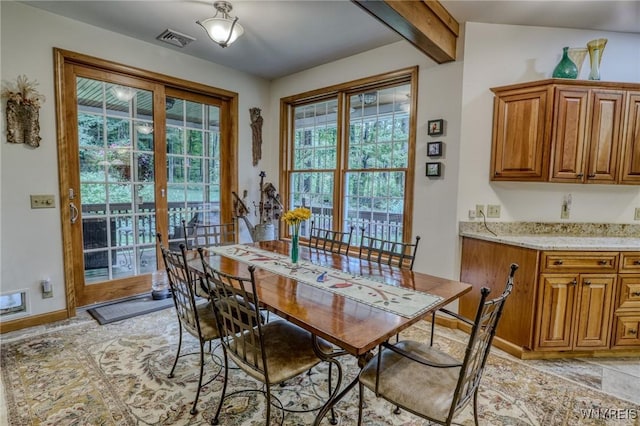 dining space with beamed ceiling and french doors