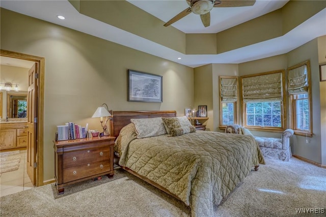 bedroom with light colored carpet, ensuite bath, and ceiling fan